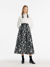 a lady in camellia jacquard pleated horse-faced maxi skirt with white shirt